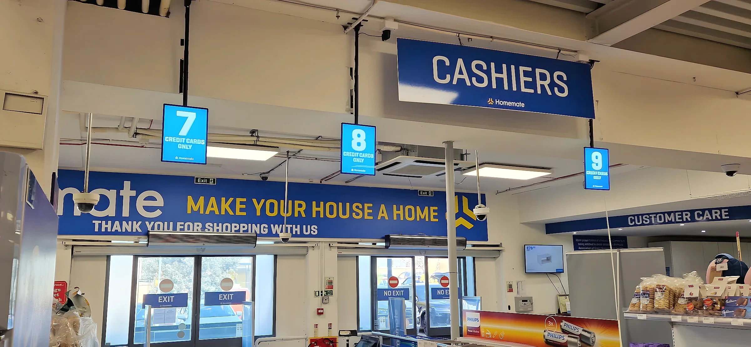 Blue overhead cashiers sign with numbered lane boxes above supermarket checkouts