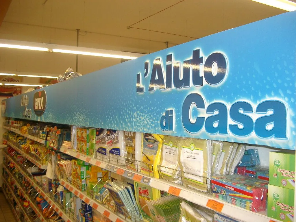 Blue printed panel with lettering running above a stocked supermarket aisle