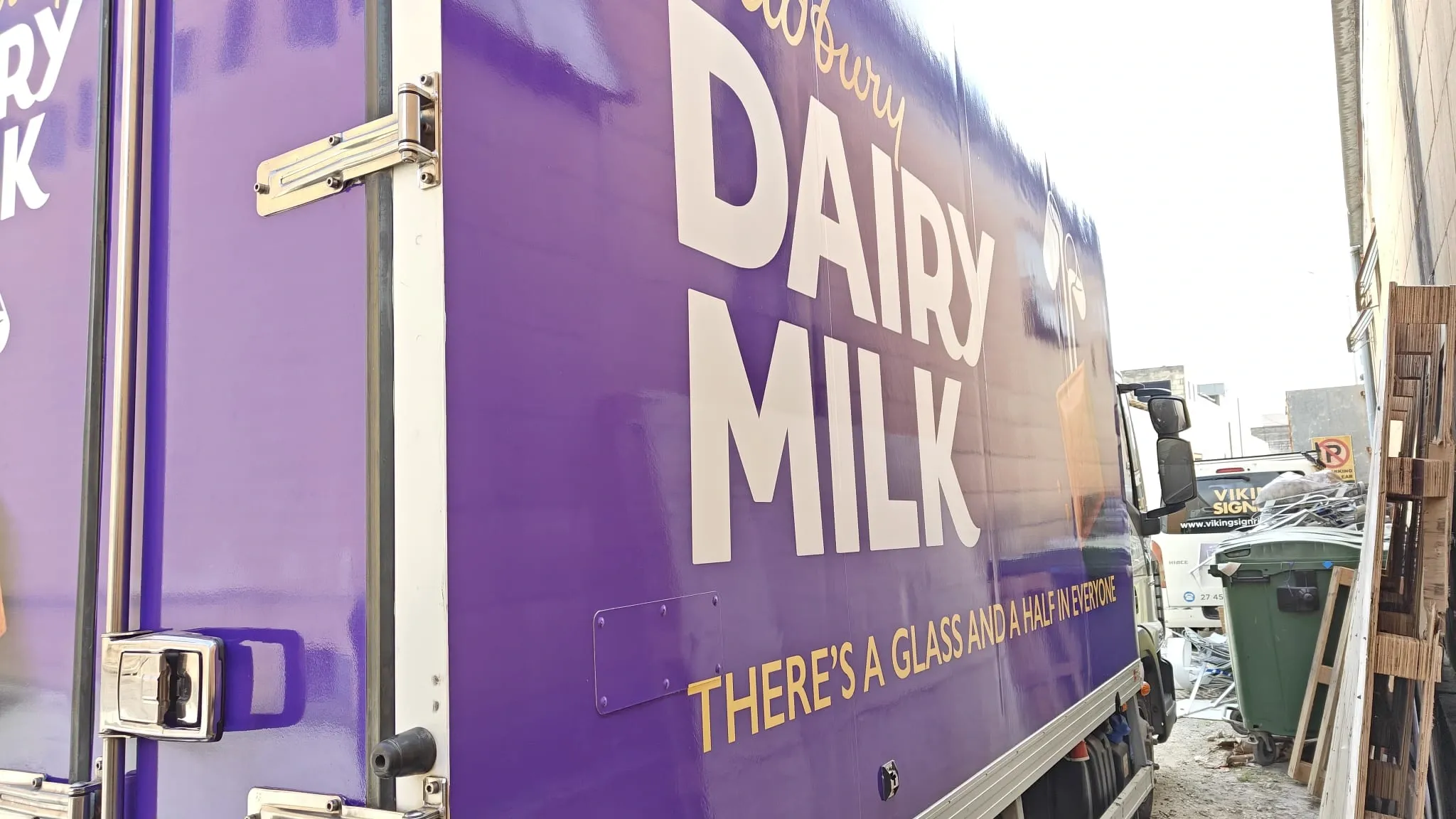 Purple wrapped truck body with large white confectionery brand lettering, photographed close up