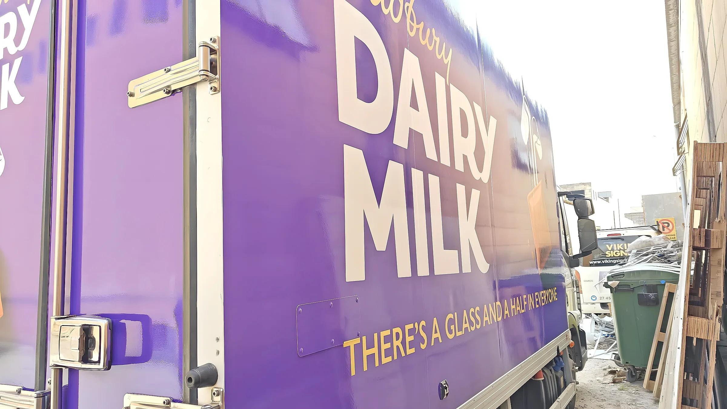 Purple wrapped truck body with large white confectionery brand lettering, photographed close up
