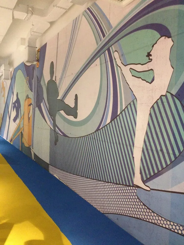 Corridor lined with a pop-art printed wall covering in blue, cream and purple