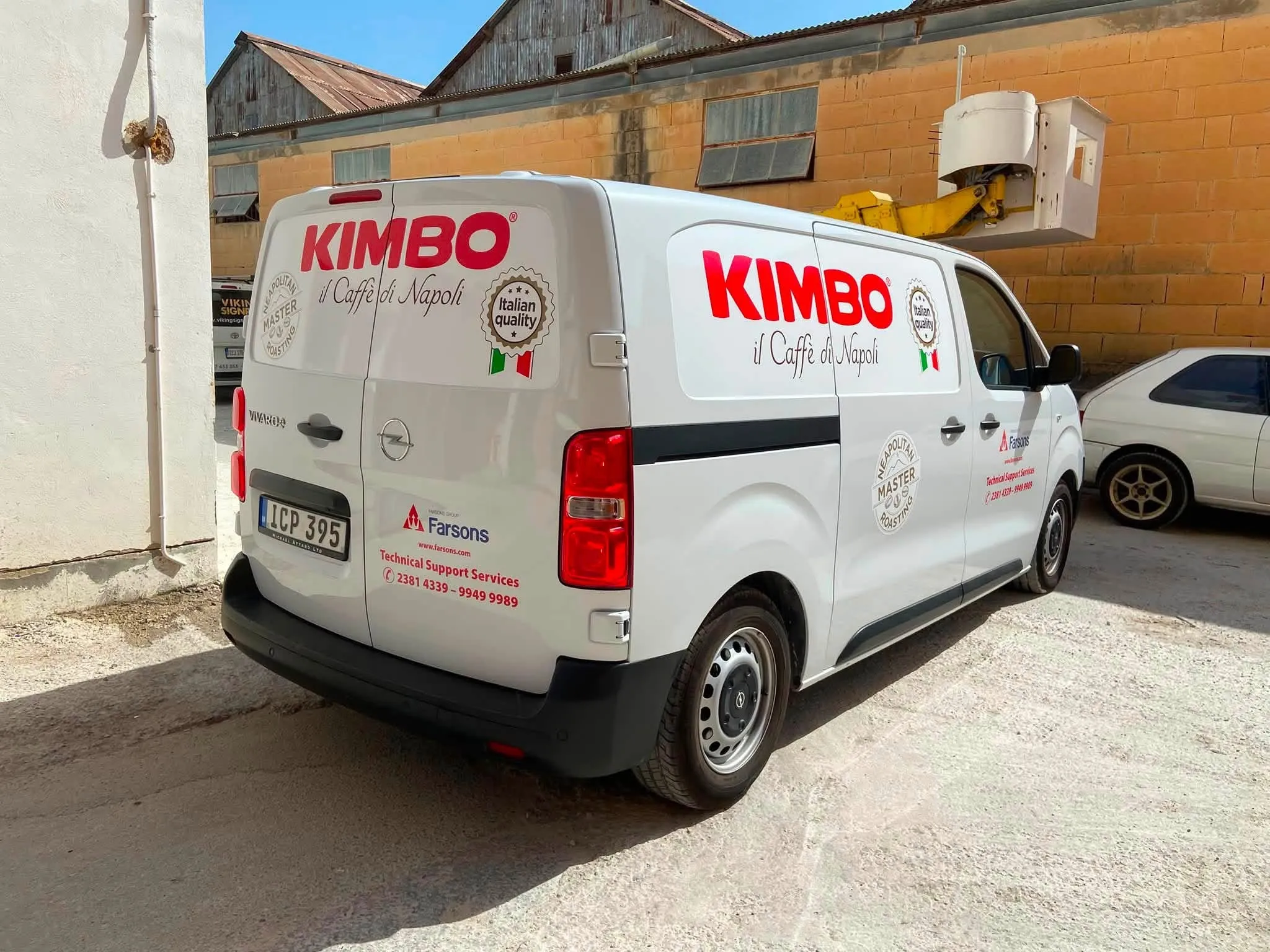White van carrying red brand lettering on both the rear door and the flank, a circular quality badge, and small distributor and support contact lines low on the rear