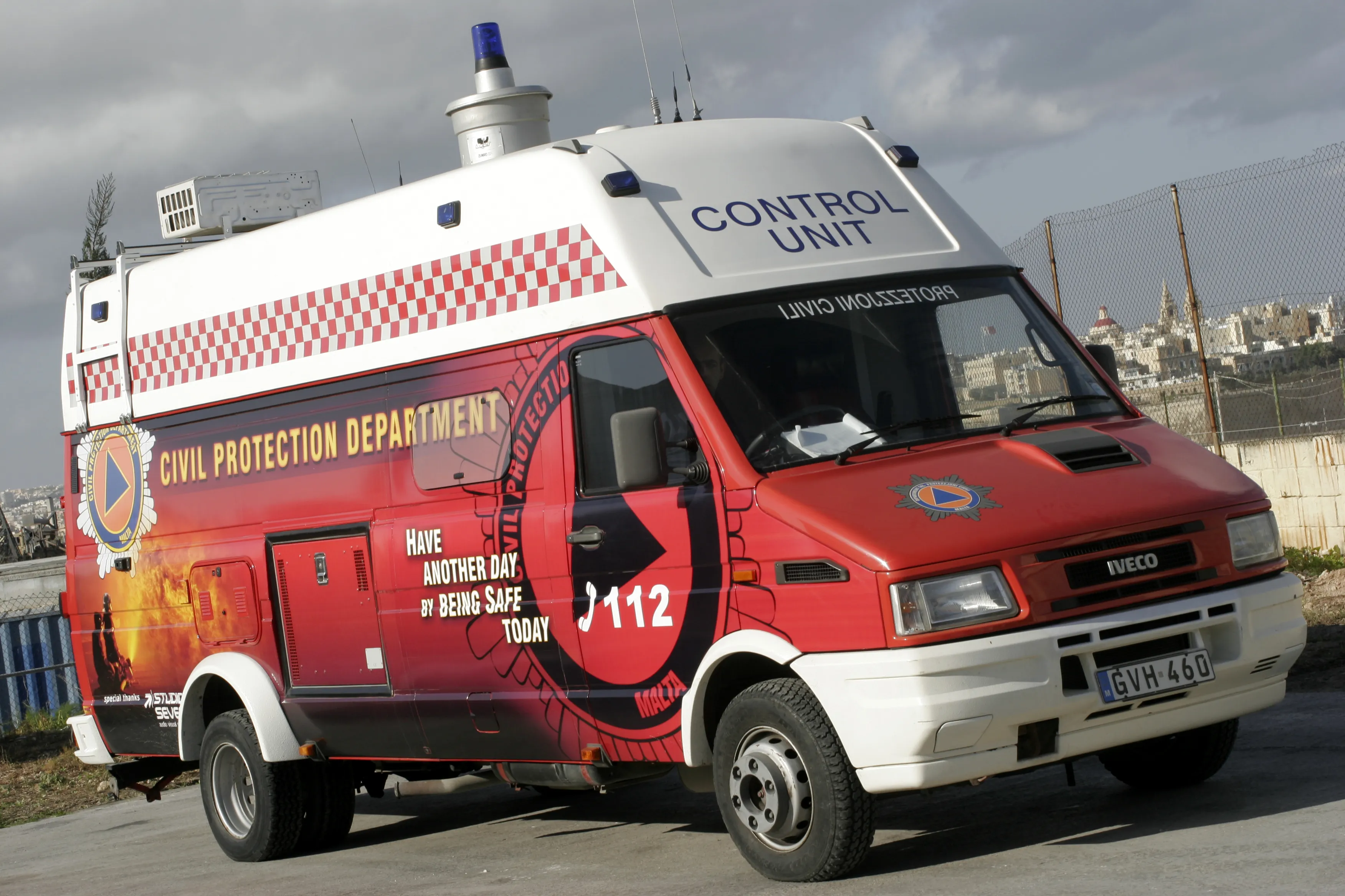 Emergency control unit with a red lower body carrying a photographic scene, a red and white chequered band, department lettering, a crest and an emergency number