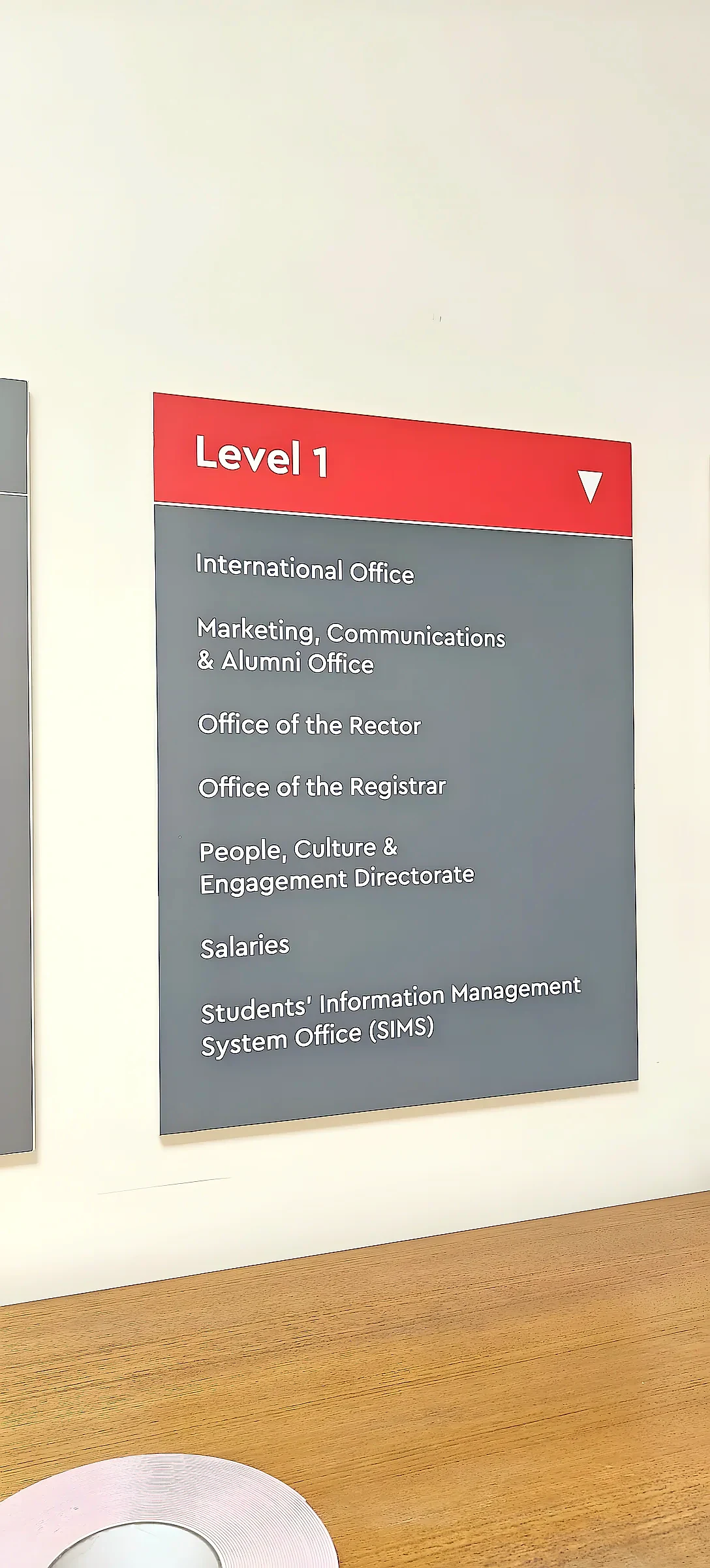 Grey wall directory panel with a red header reading Level 1 above a list of offices