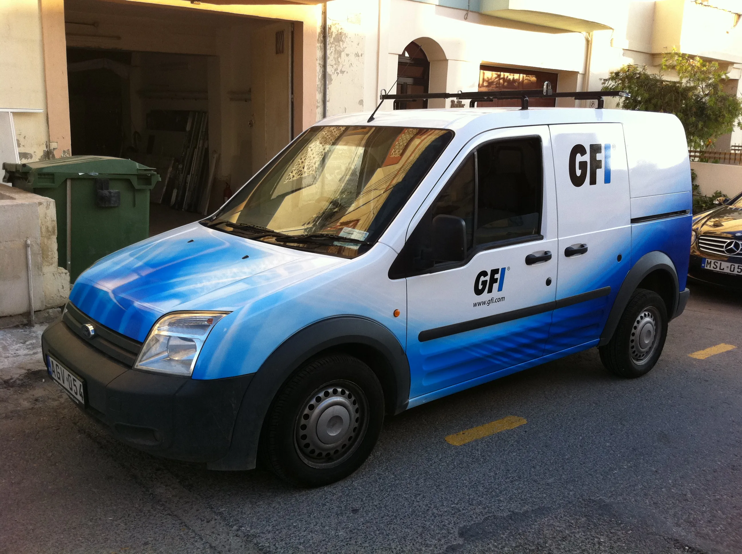 Van with a white upper body and a blue gradient sweeping up the lower body and over the bonnet, the mark set on the rear panel and repeated on the sliding door
