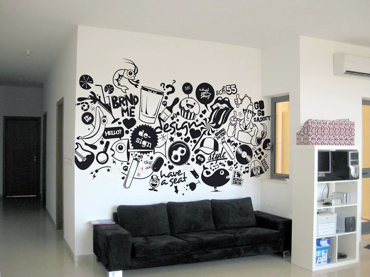 Black doodle-style line-art mural covering a white wall above a black sofa in an office lounge