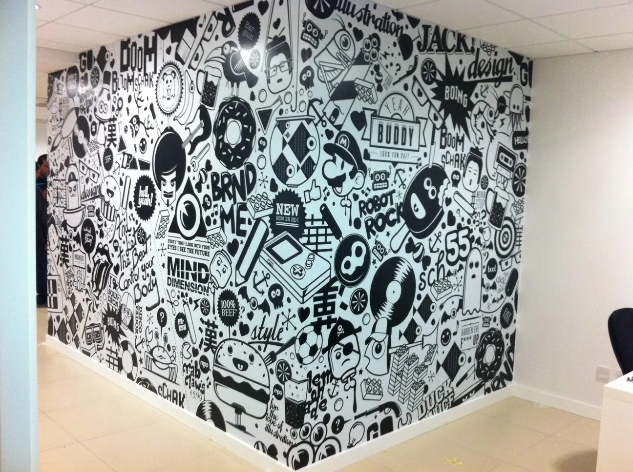 Office wall covered in a dense black and white illustrated pattern, wrapping around a corner
