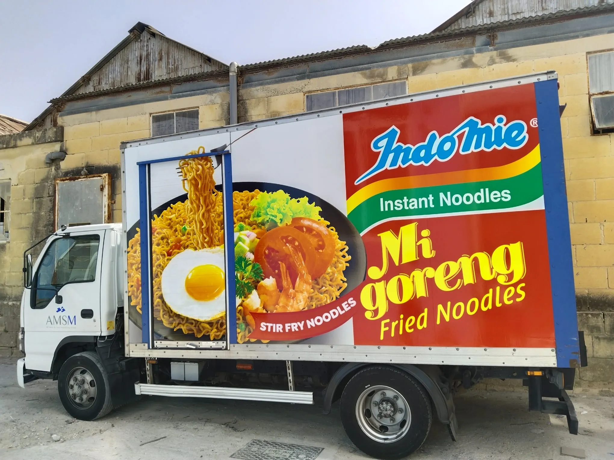 Box truck printed with a large noodle dish and pack image along its full side
