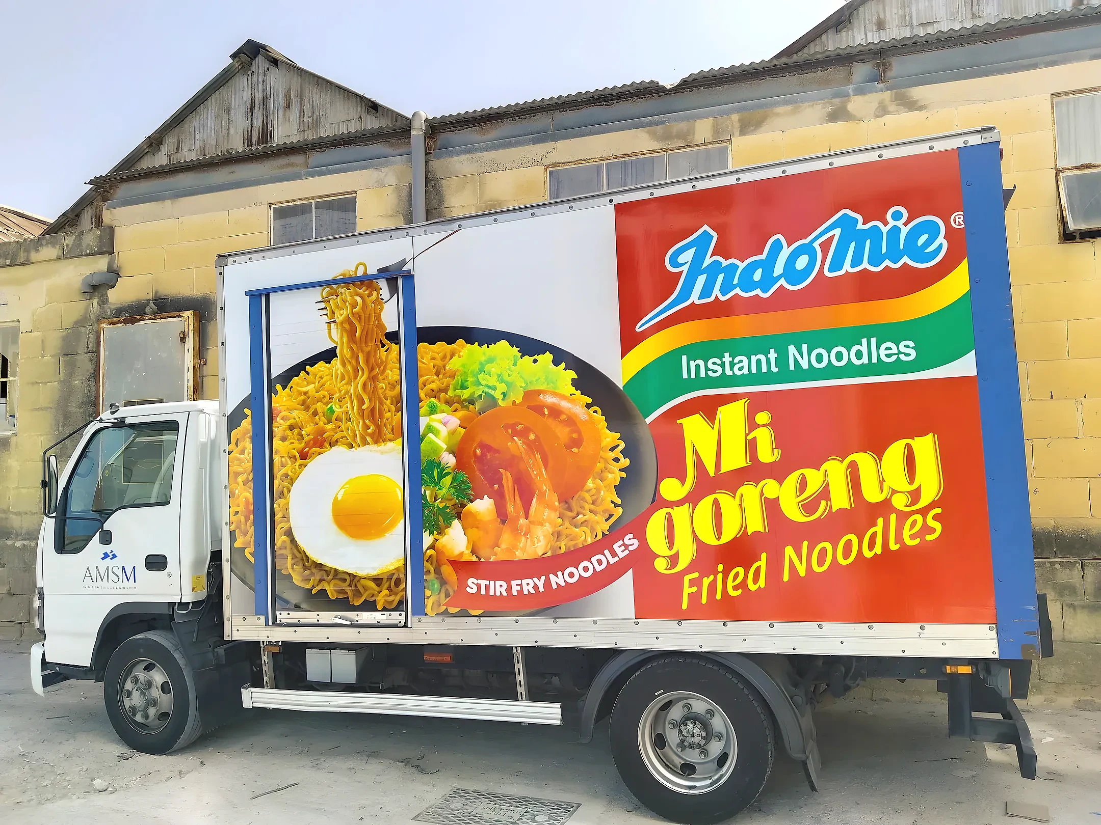 Box truck printed with a large noodle dish and pack image along its full side