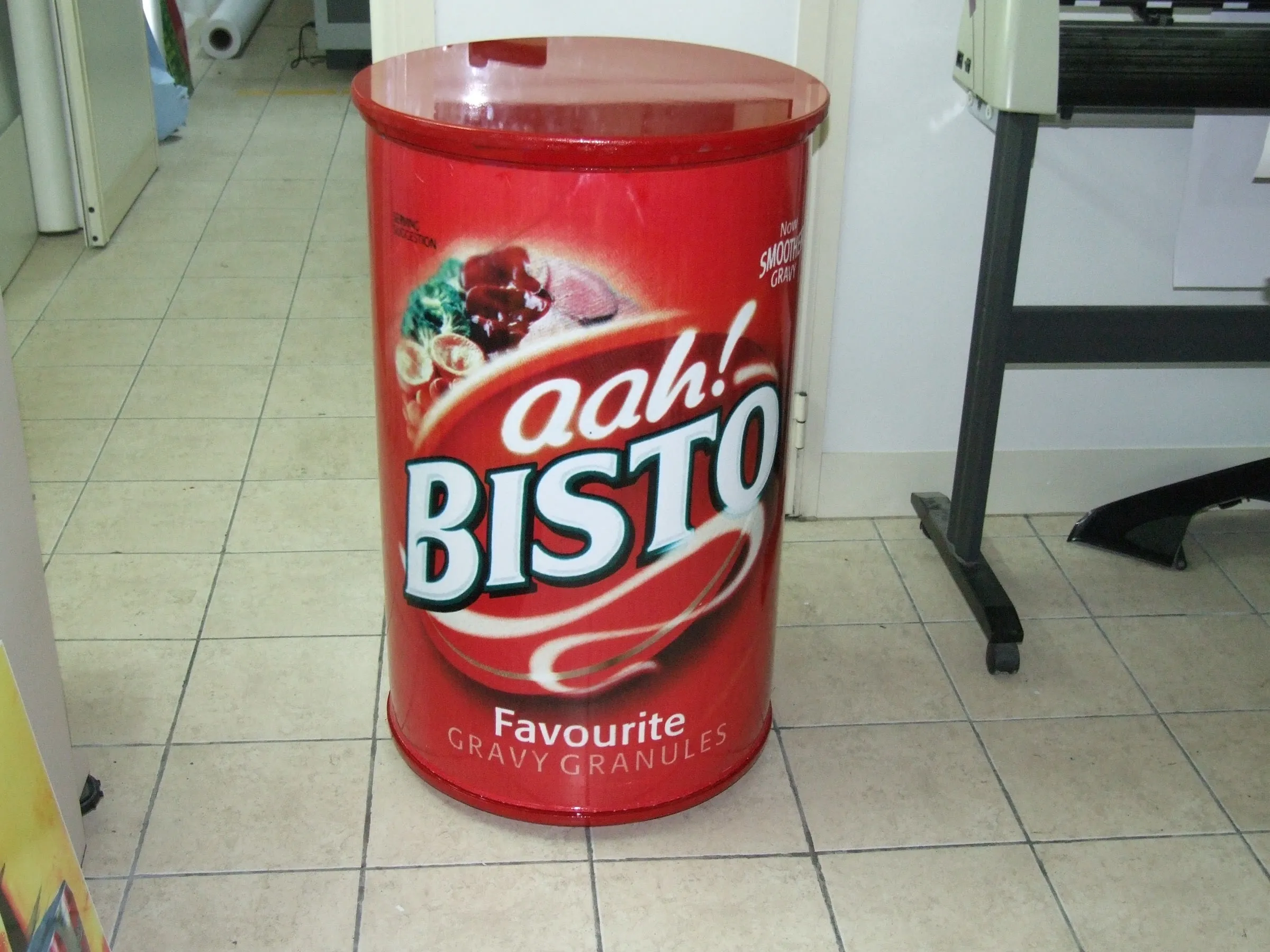 Oversized cylindrical product replica standing on a workshop floor