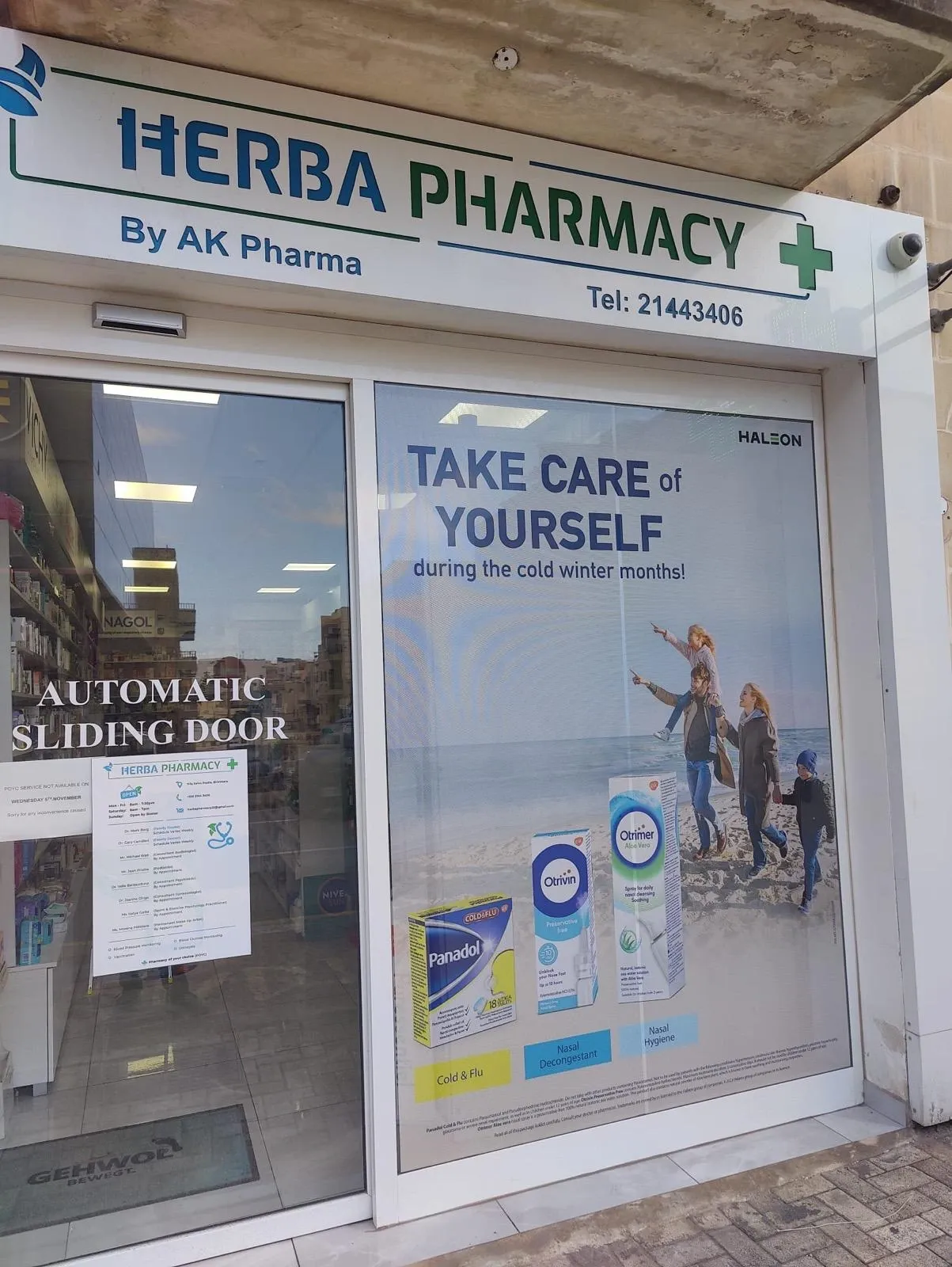 Printed one-way vision window panel showing a seasonal health campaign beside a pharmacy fascia sign