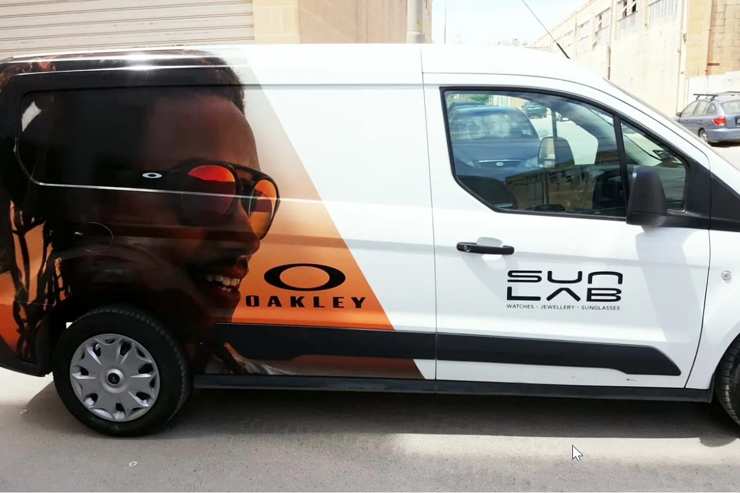 White panel van carrying a full photographic wrap shown side-on in a workshop yard