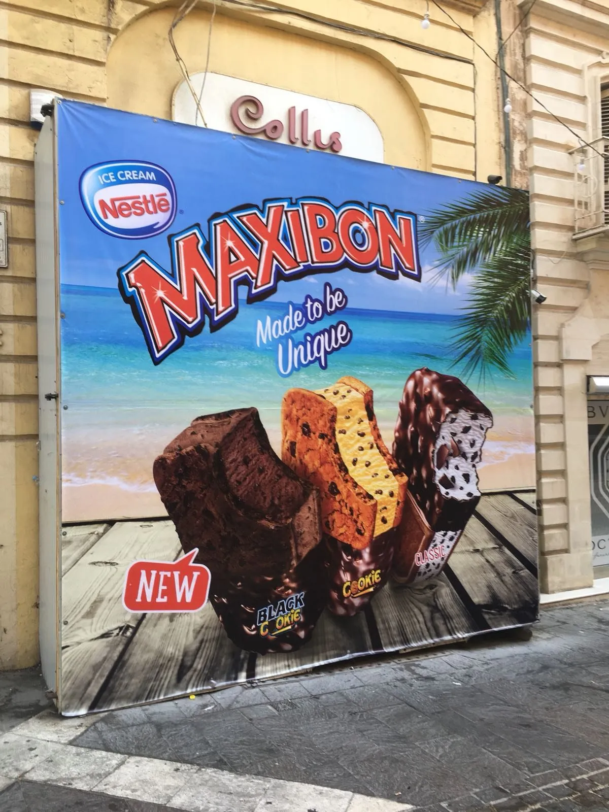 Printed banner showing ice cream products mounted flush to a rendered building wall