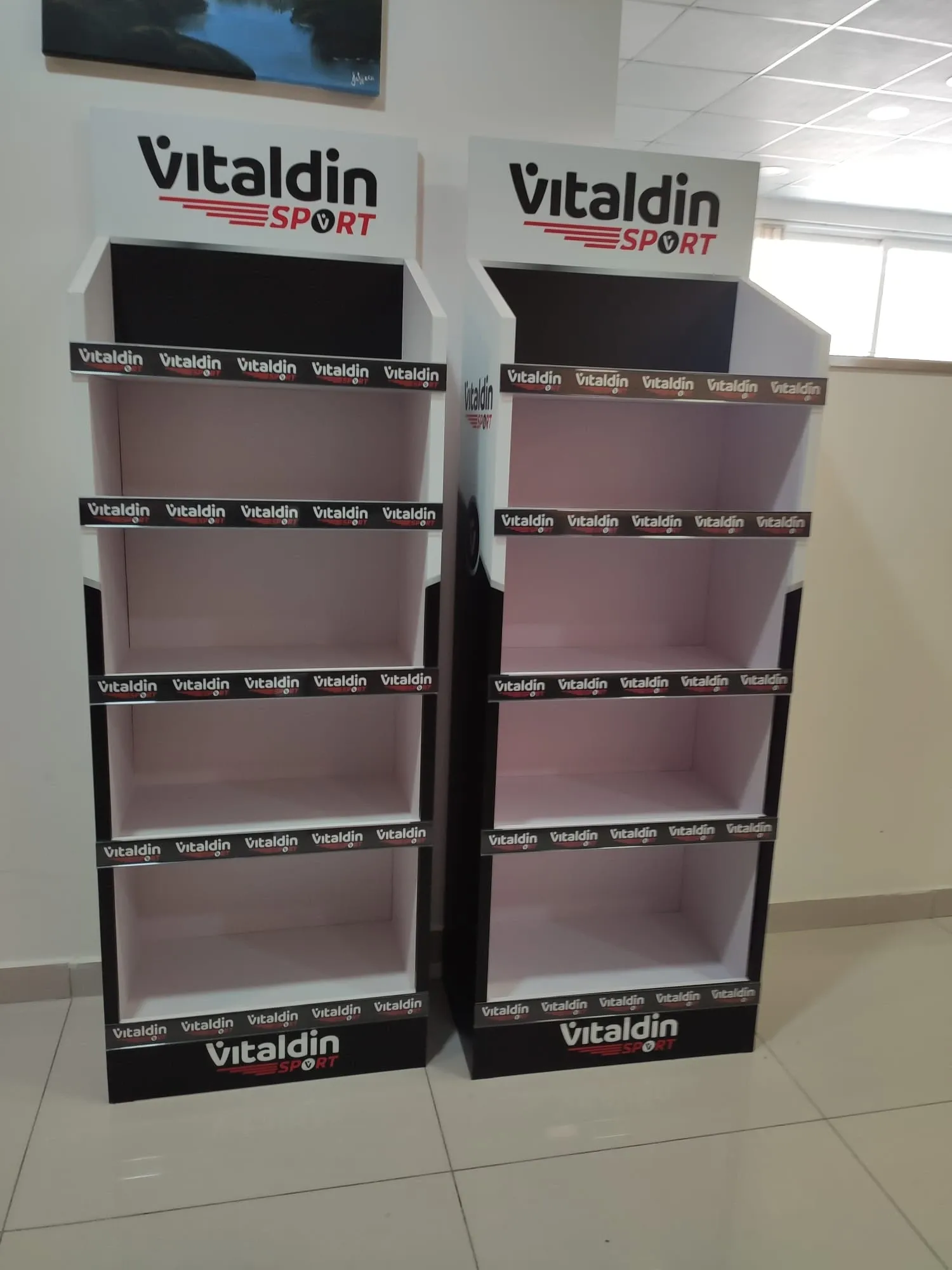 Two identical branded four-shelf display units standing side by side in a showroom