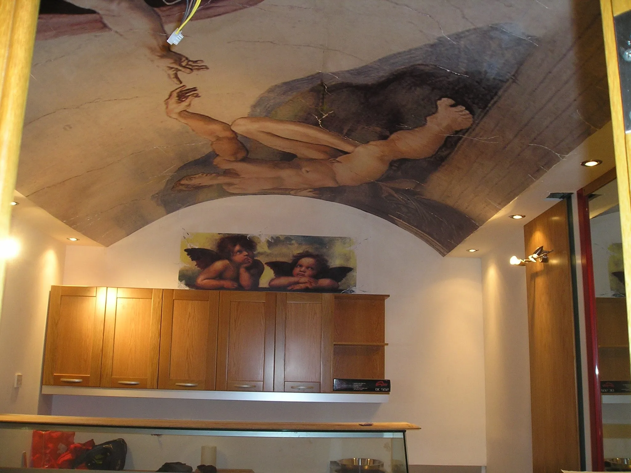 Classical fresco-style mural printed across a curved vaulted ceiling above timber cabinetry