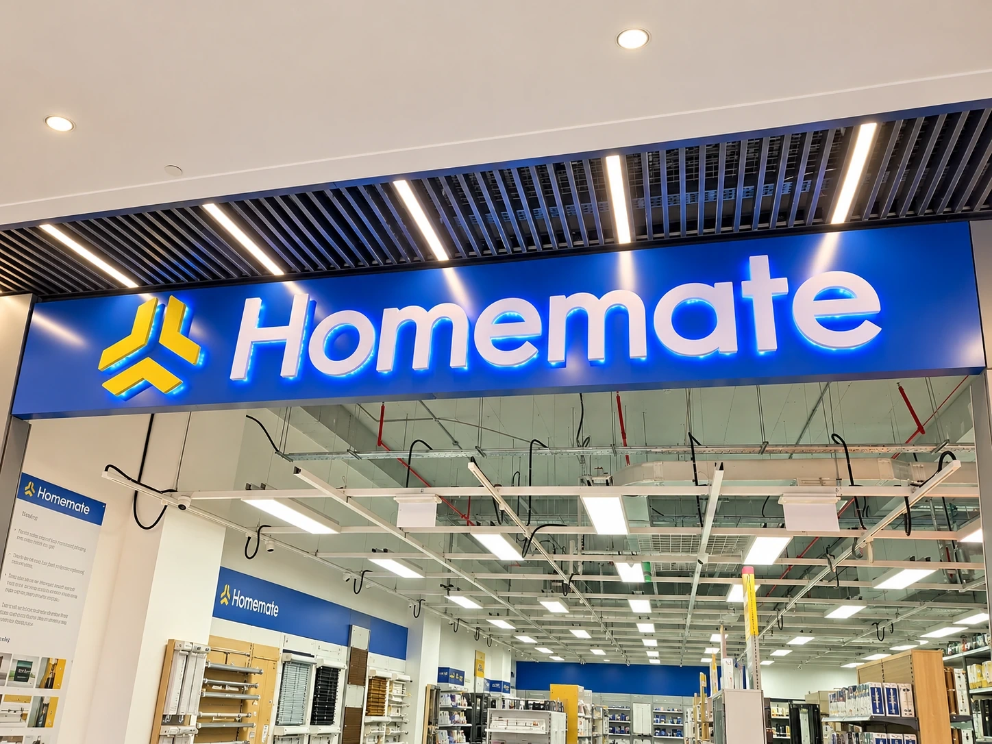Illuminated blue interior sign with white built-up lettering above a store aisle