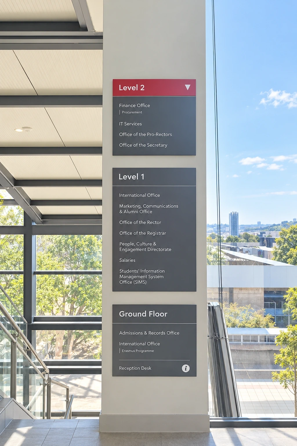 Three stacked directory panels listing the offices on each floor beside a glazed stairwell