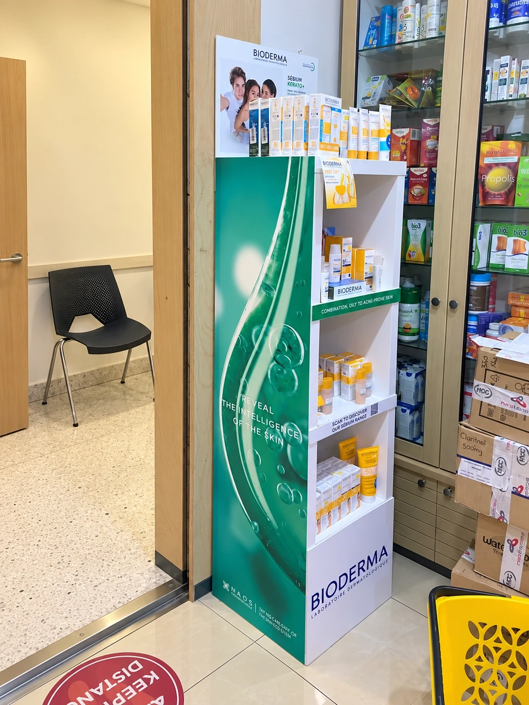 Free-standing four-shelf retail display stocked with skincare cartons in a pharmacy