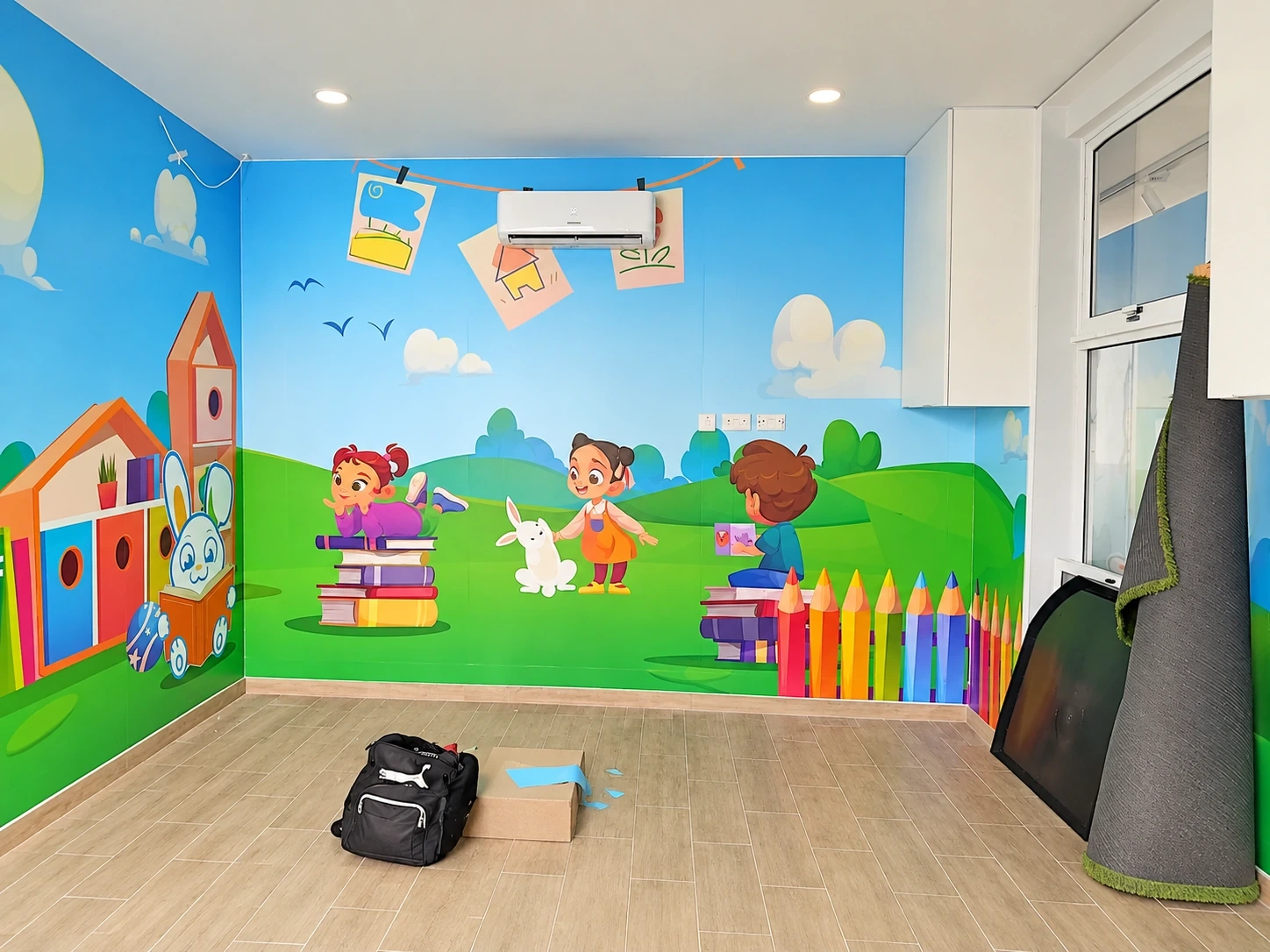 Children's playroom with printed wall murals of characters, books and oversized pencils