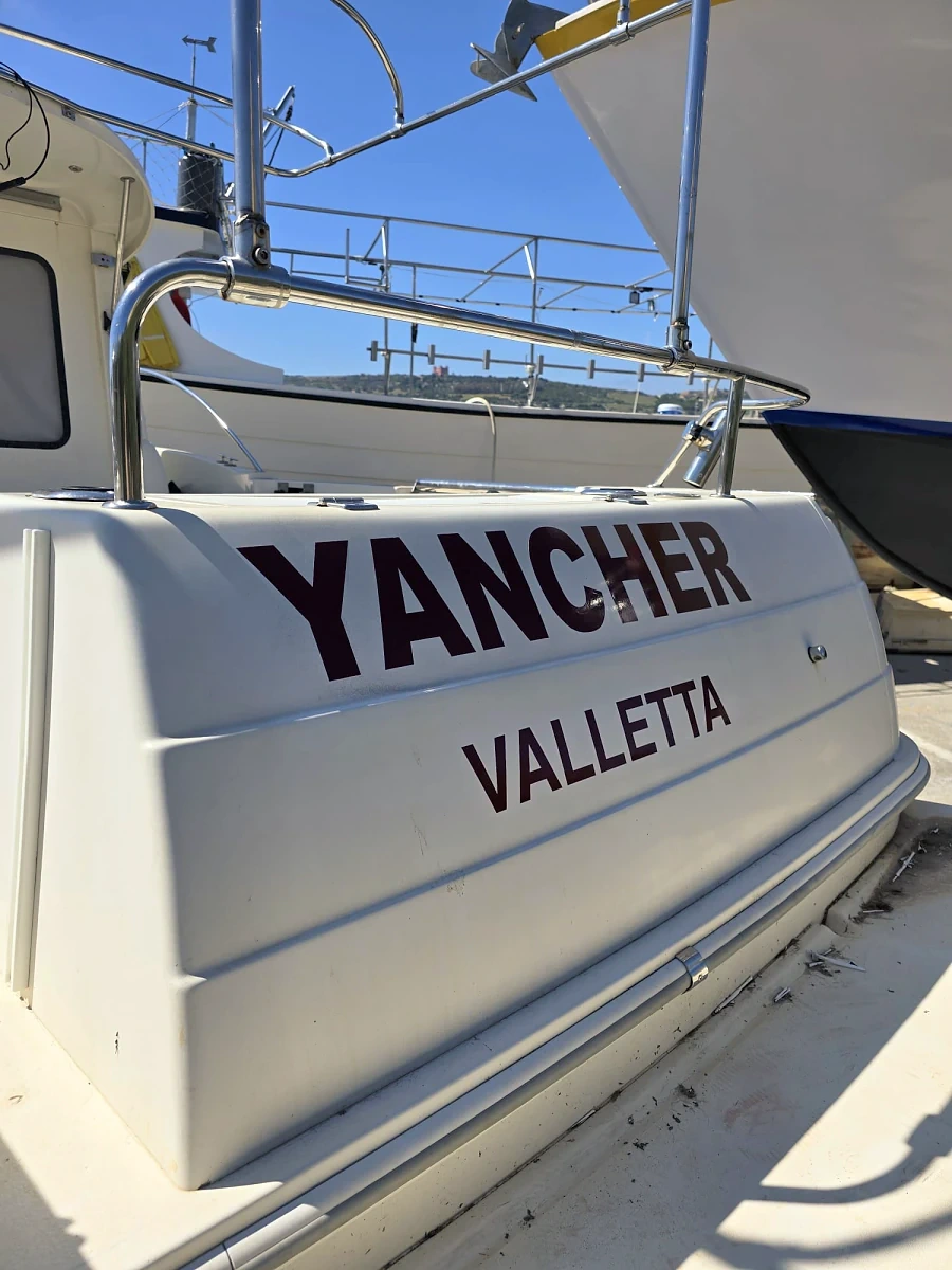 Cut vinyl boat name and port lettering applied across the transom of a yacht in a boatyard