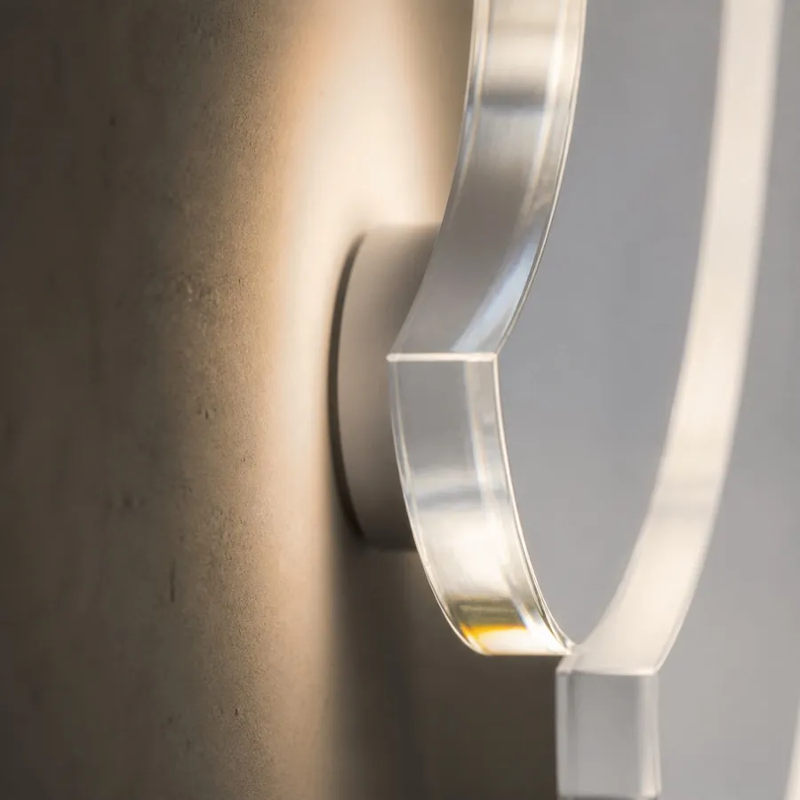 Close detail of an illuminated clear acrylic sign edge casting a soft wall halo