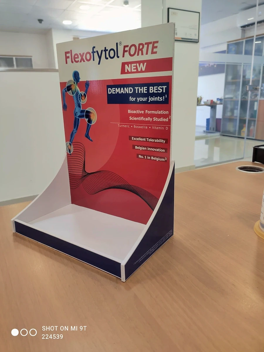 Printed counter display unit with a curved header standing on a wooden table