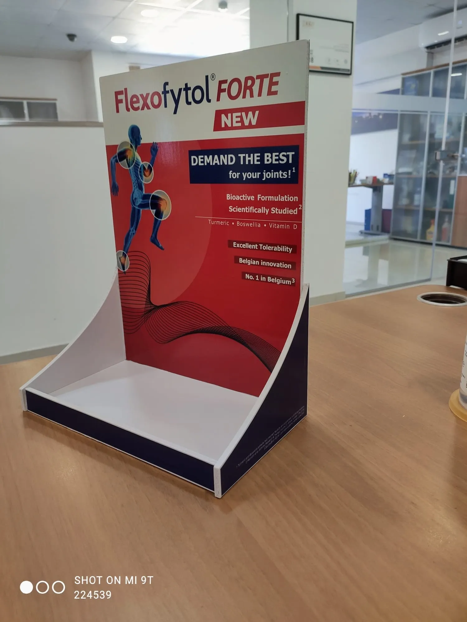 Printed counter display unit with a curved header standing on a wooden table