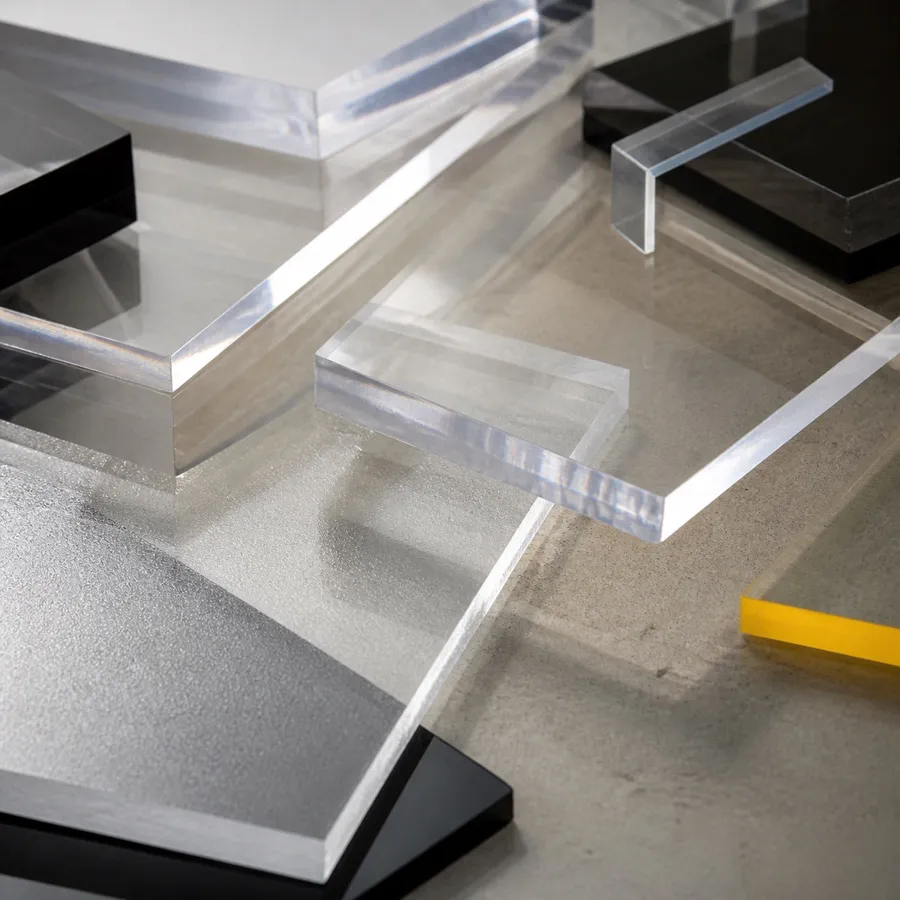 Clear acrylic fabrication offcuts refracting light across a neutral work surface