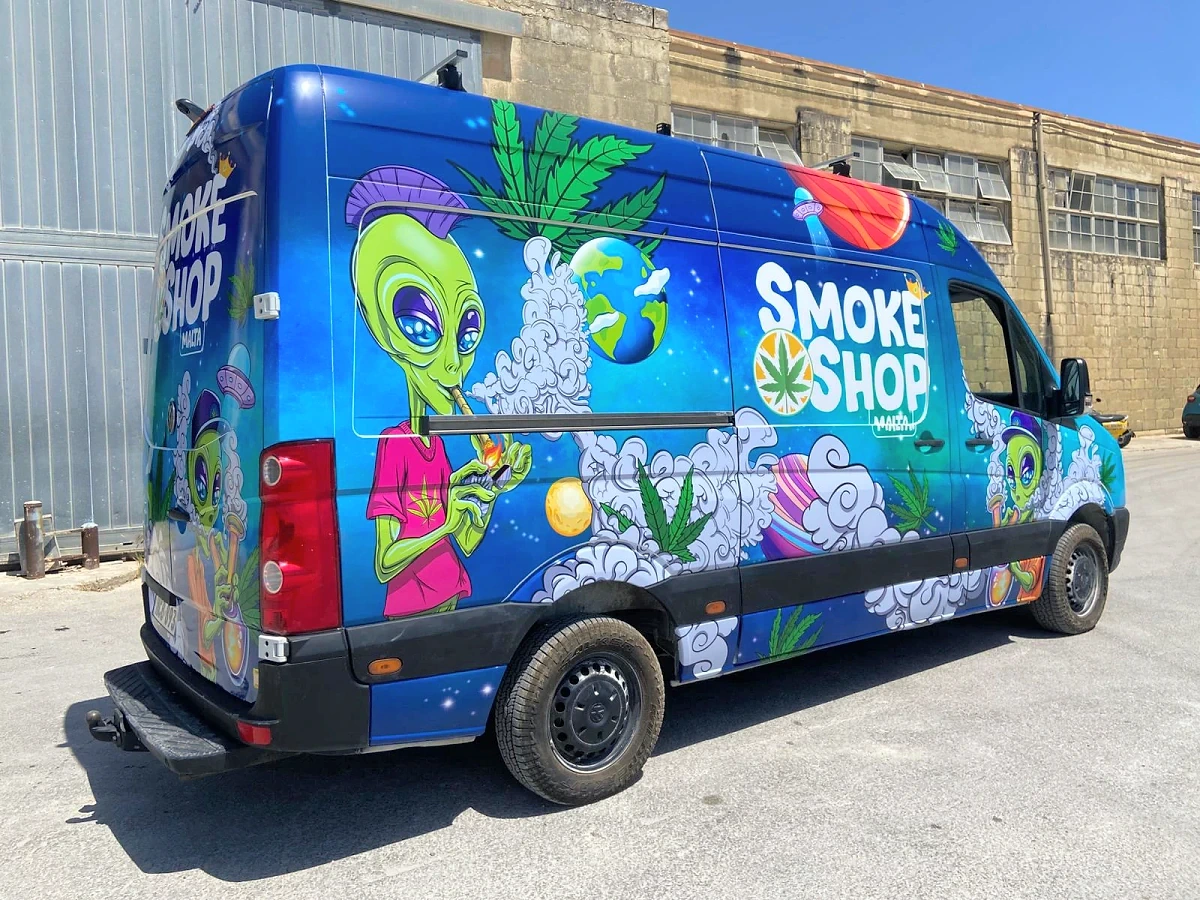 High-roof van wrapped in an illustrated blue design with cartoon characters and foliage