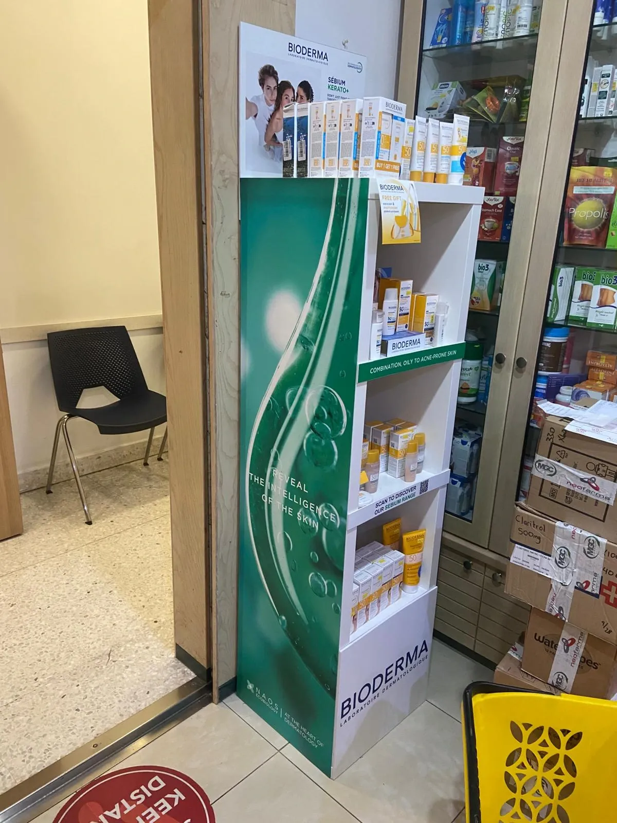Free-standing four-shelf retail display stocked with skincare cartons in a pharmacy