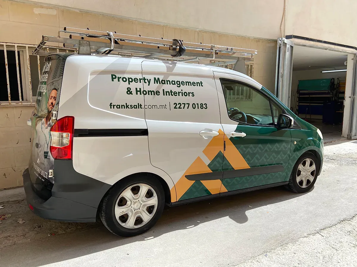Small van in green and white livery with a geometric pattern and a roof rack