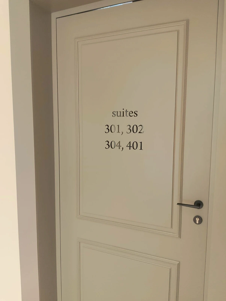 Cut vinyl suite numbers applied to a panelled cream door