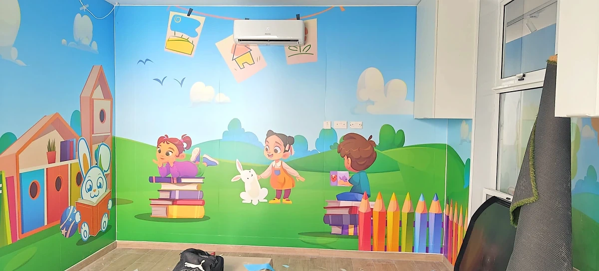 Children's playroom with printed wall murals of characters, books and oversized pencils