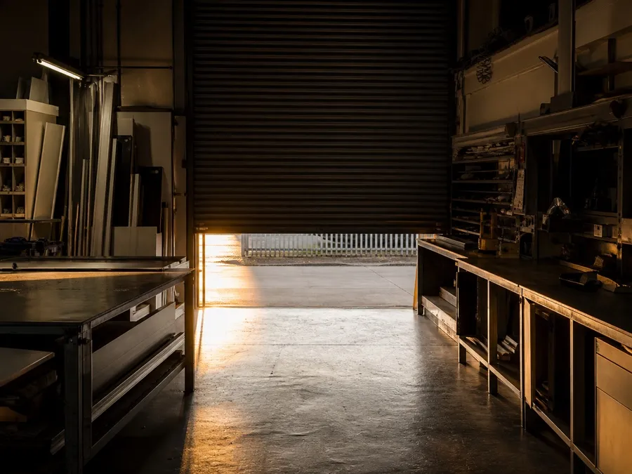 Quiet fabrication workshop at the end of the day with the shutter half down