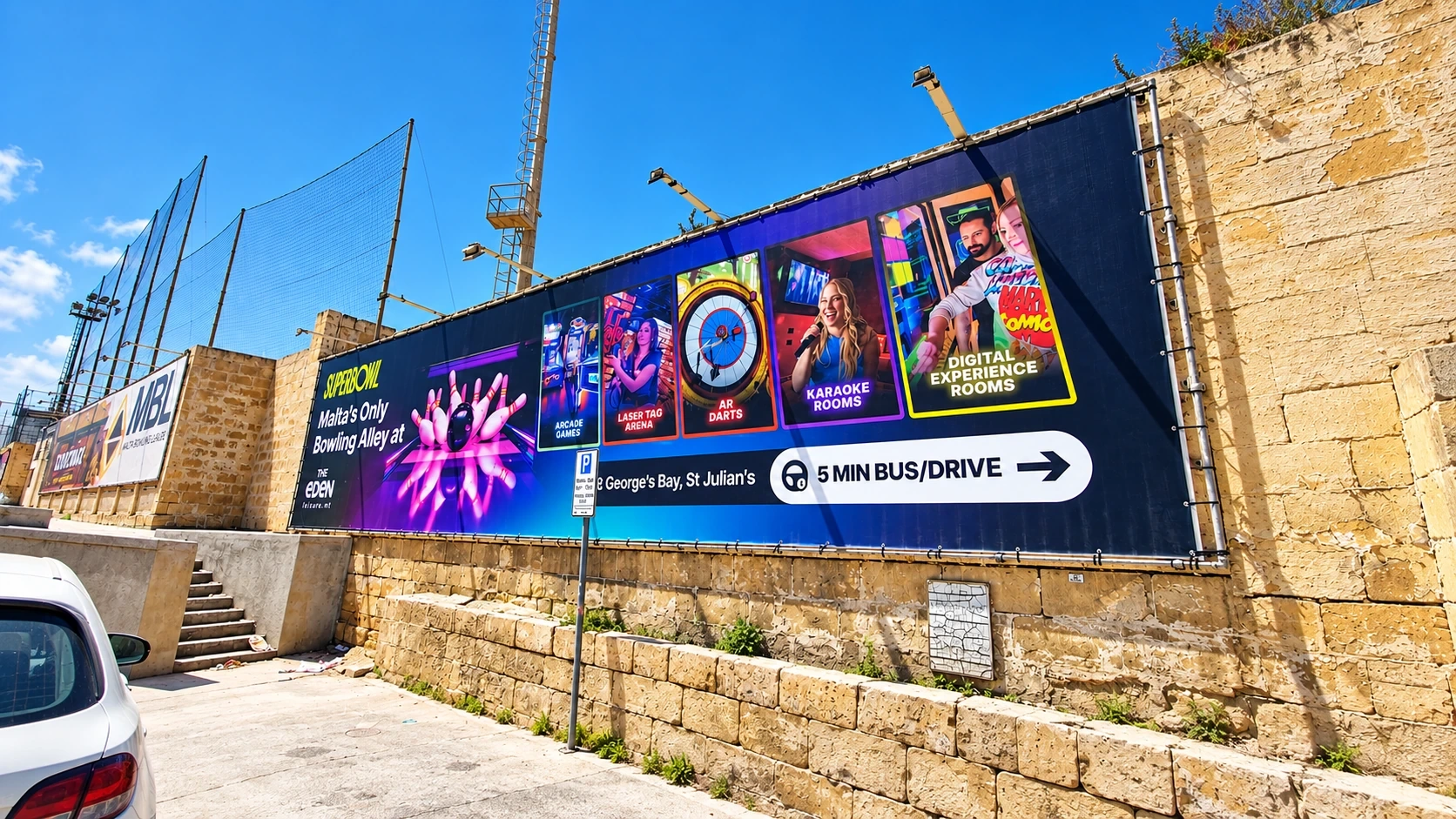 Colorful entertainment banner installed along a limestone boundary wall