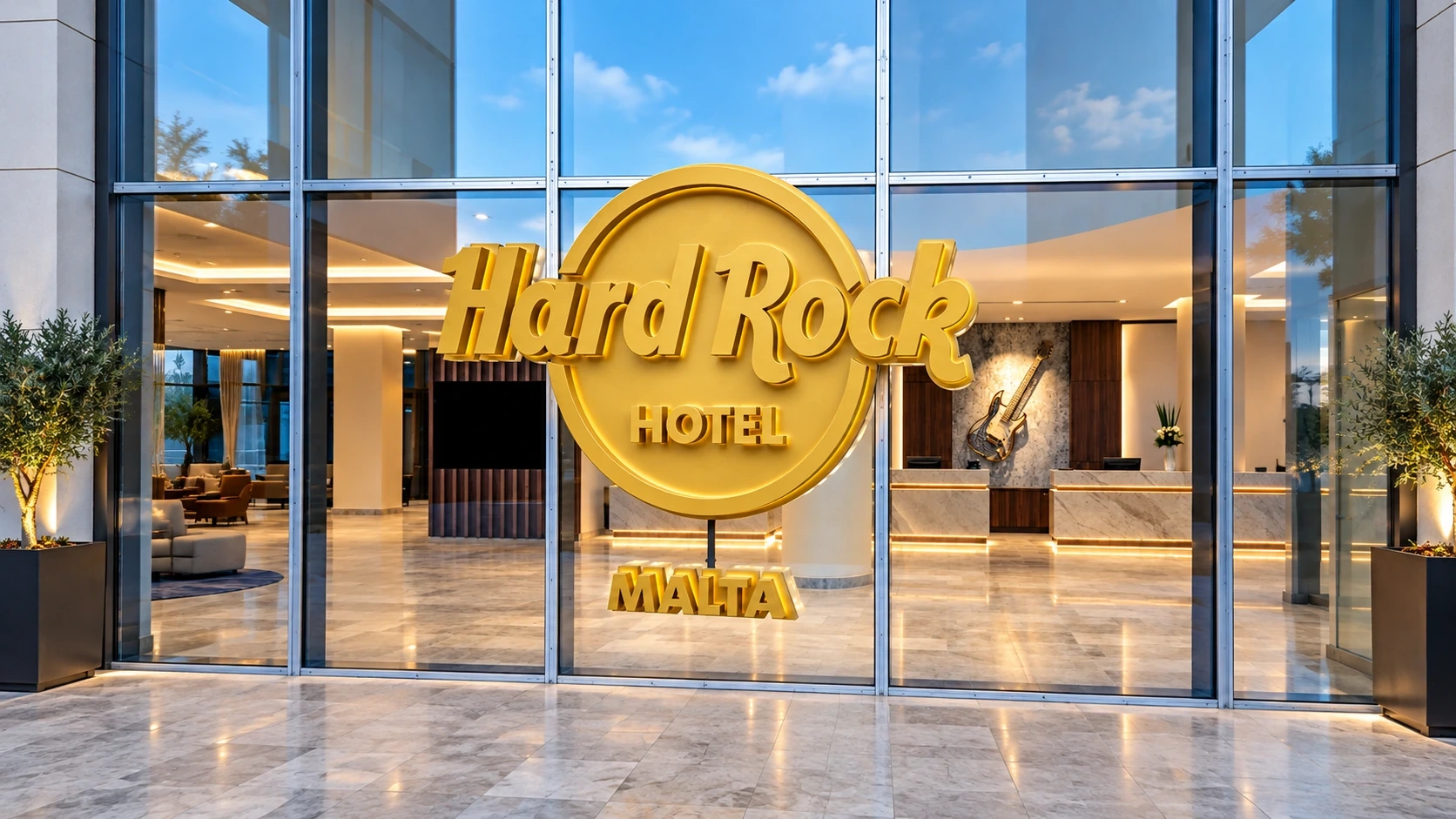 Gold Hard Rock Hotel Malta lettering on glass in front of the hotel reception