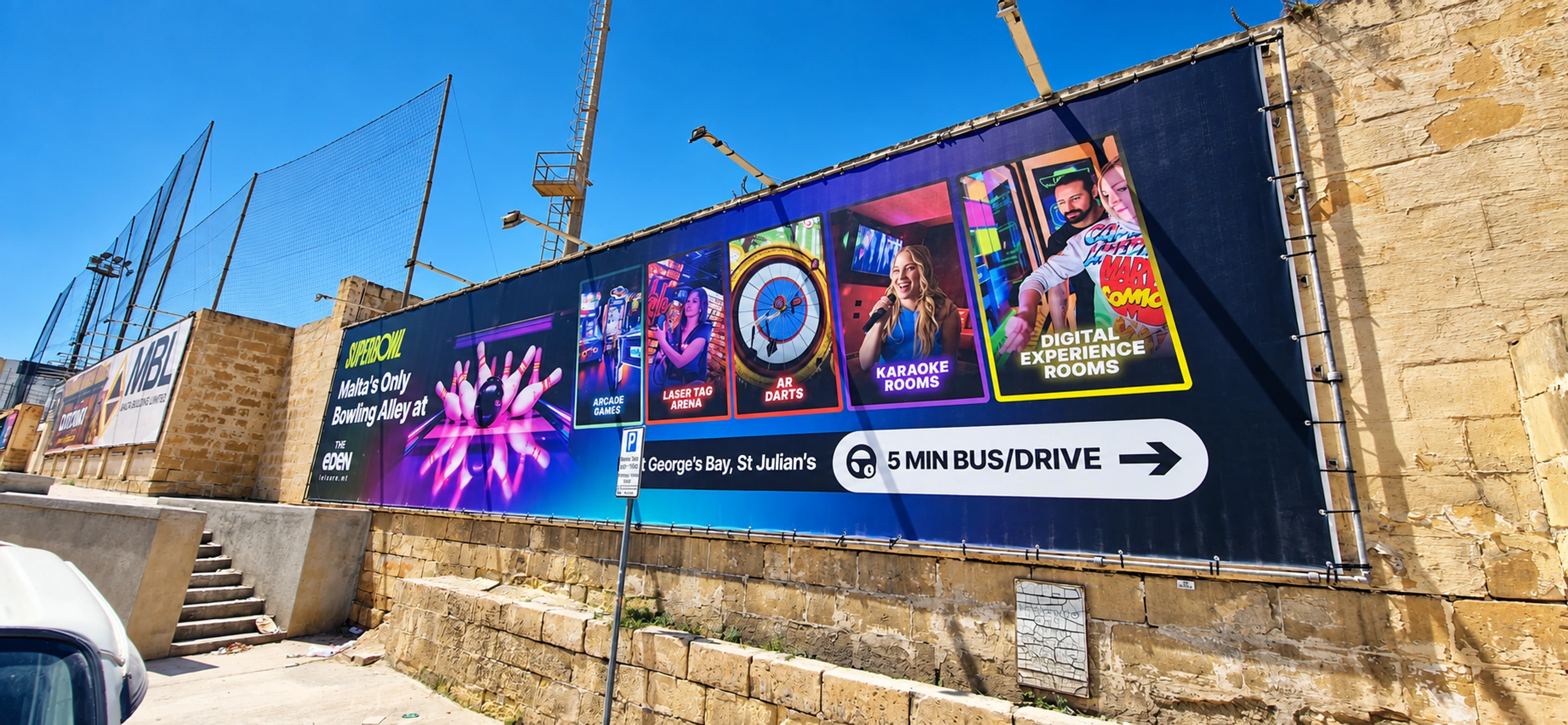 Colorful entertainment banner installed along a limestone boundary wall