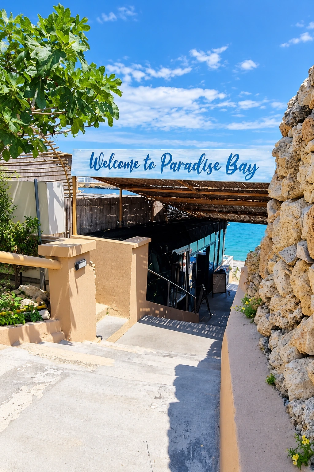 Hand-lettered Welcome to Paradise Bay sign over the path down to a beach