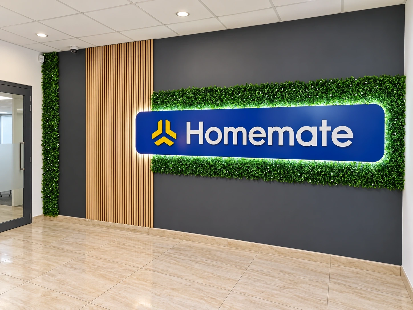 Halo-lit logo panel set into a living green wall beside timber slats in a reception area