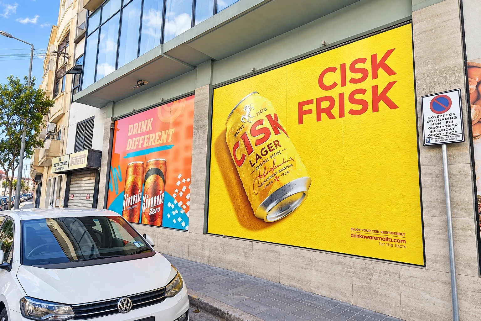 Yellow window graphic of a lager can beside a pink panel of soft drink cans on a street frontage