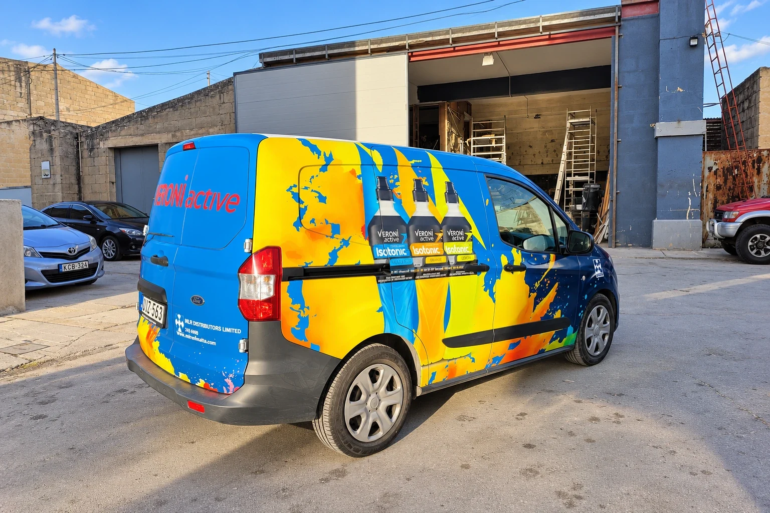 Blue, yellow and orange patterned van wrap with three drink bottles printed on the side door