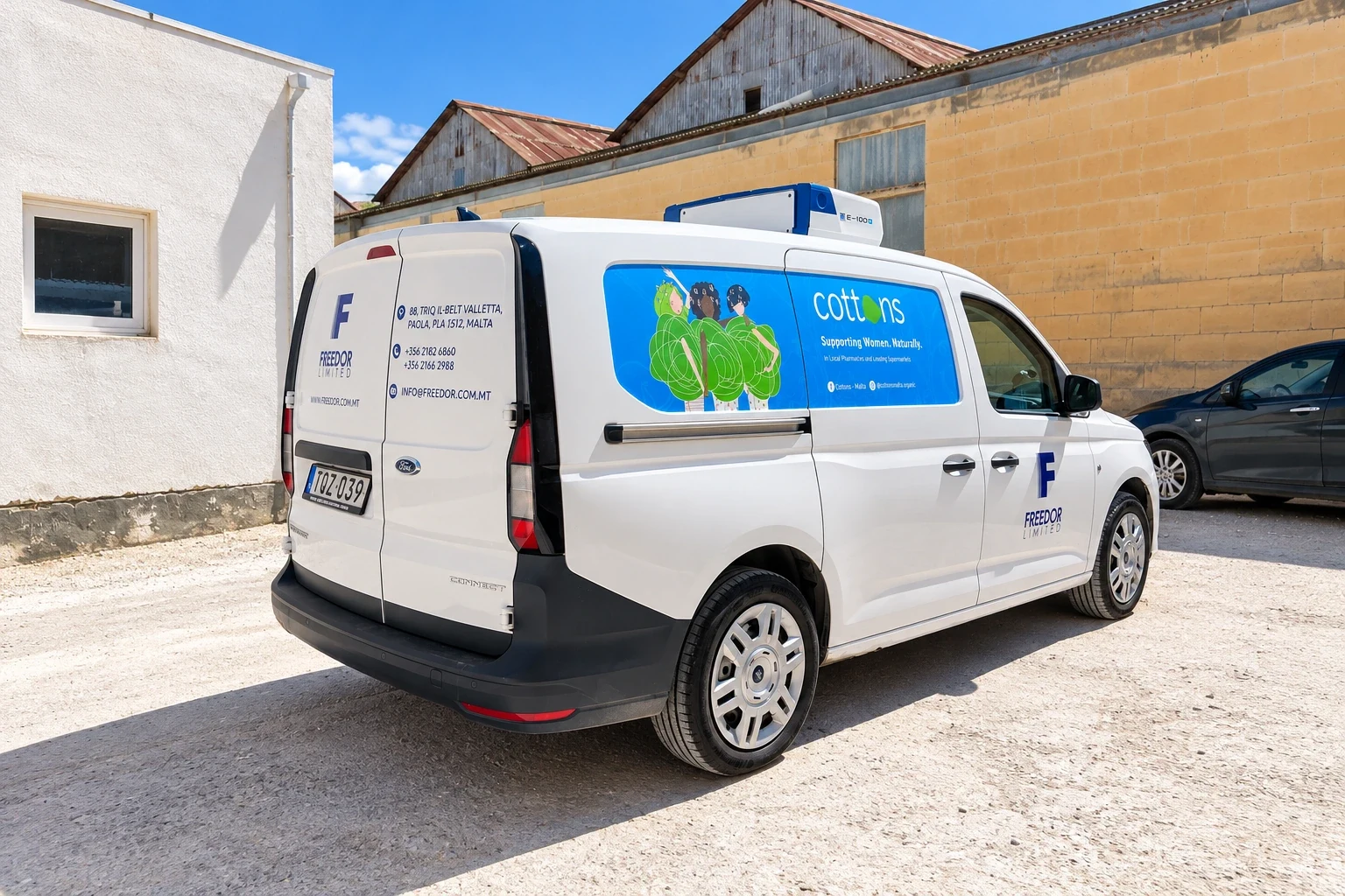 White van with a blue company mark, address text and an illustrated blue panel on the sliding door