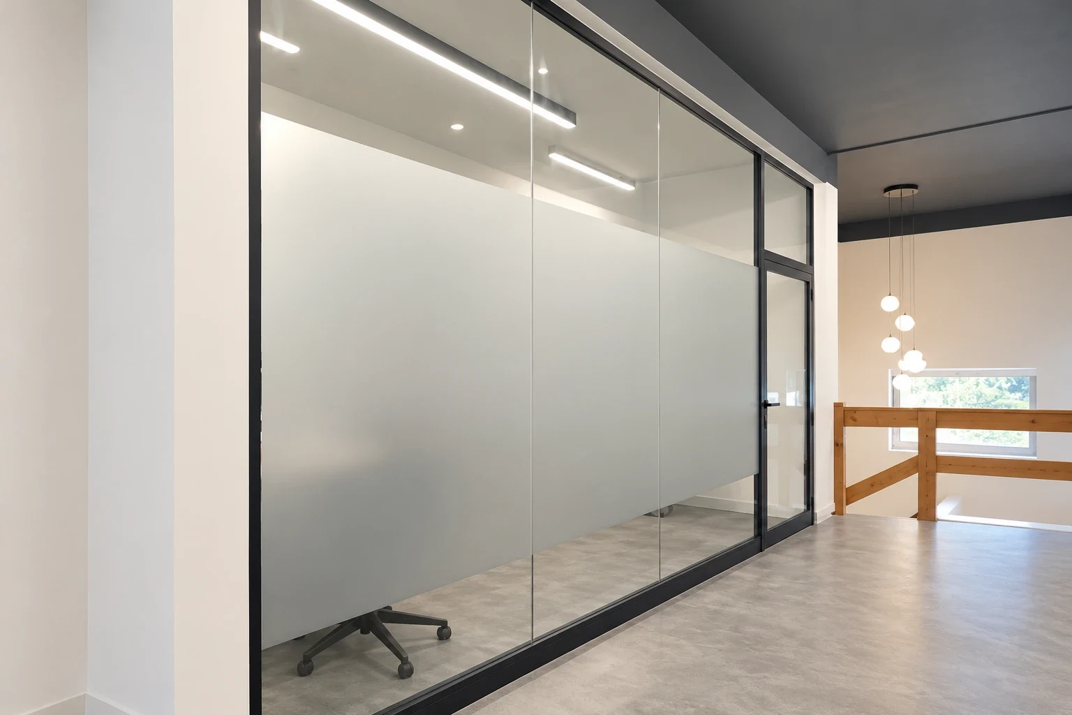 Full-height glass office wall covered in plain frosted film with a clear strip above