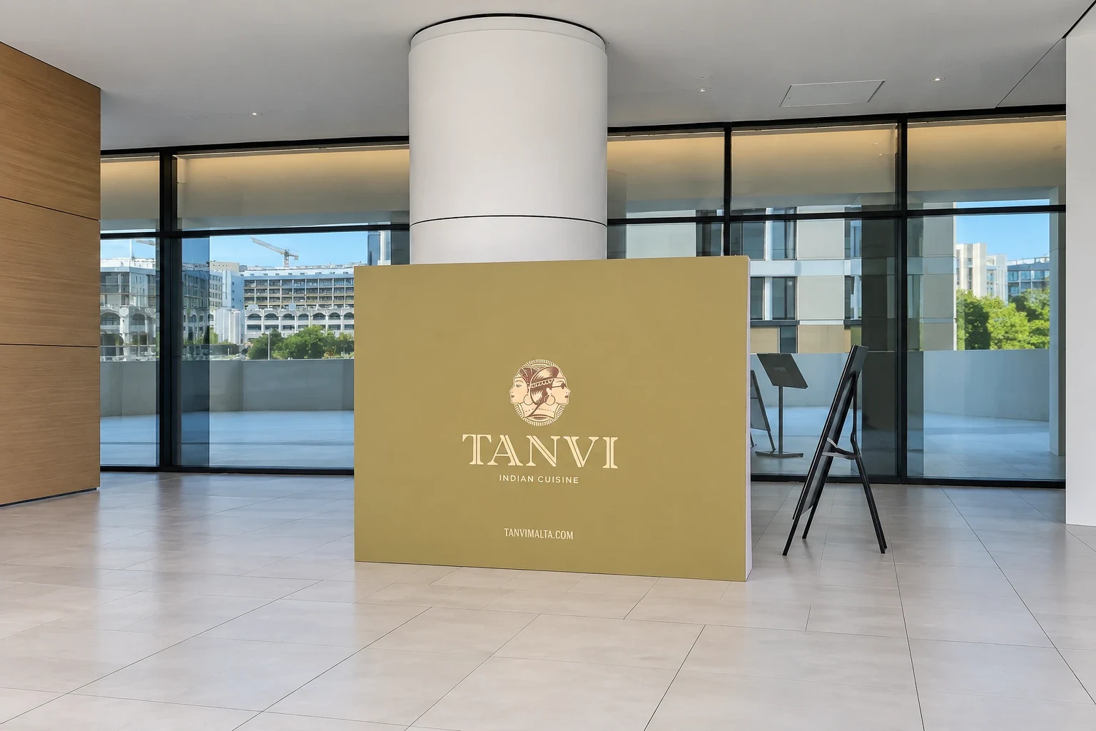 Gold branded plinth panel for an Indian restaurant standing in a tiled lobby