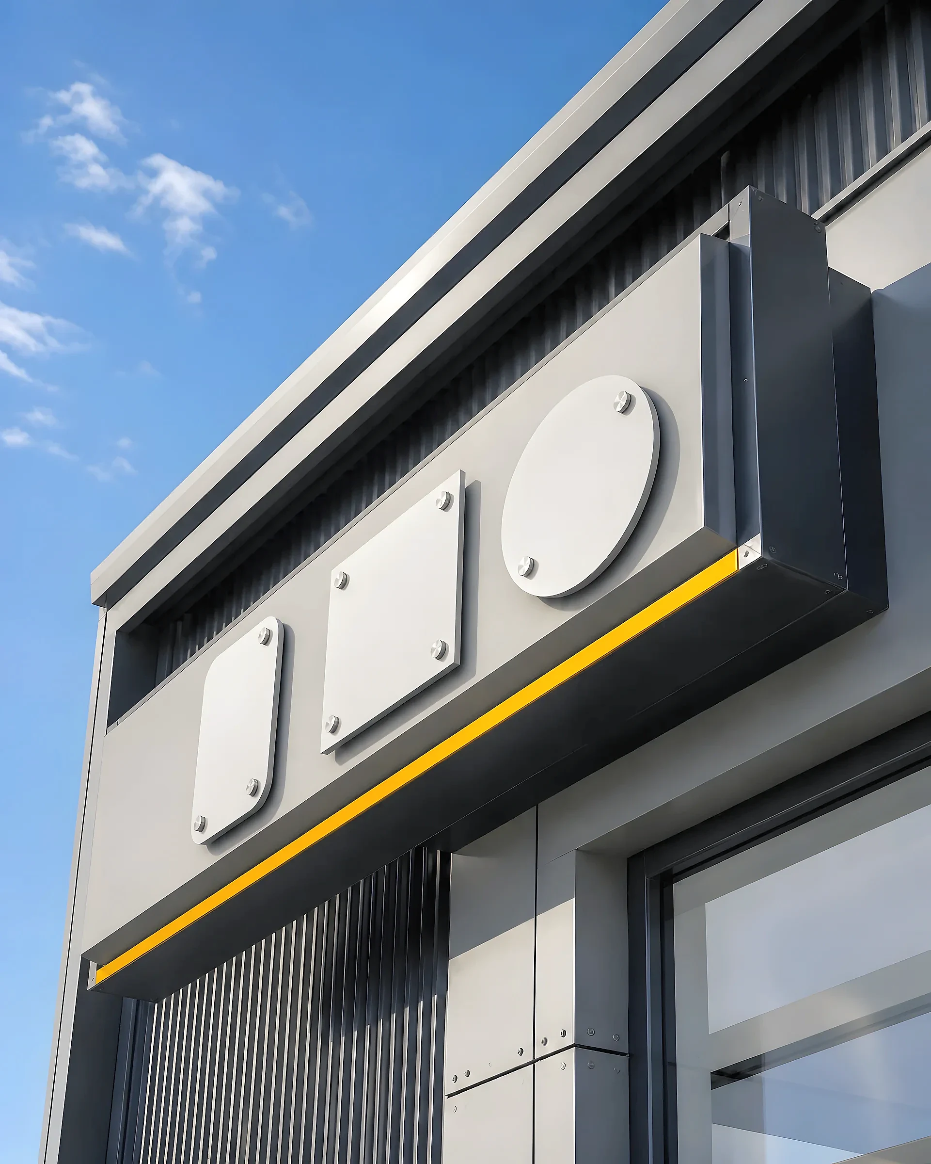 Blank geometric dimensional sign forms fixed to a metal fascia beneath an open sky